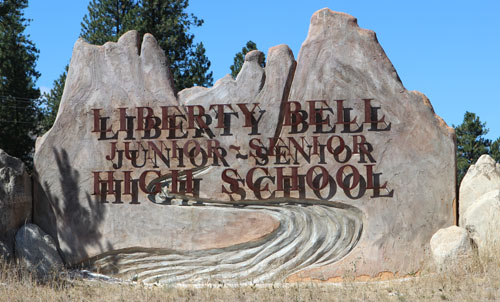 photo of liberty bell stone and steel high school sign
