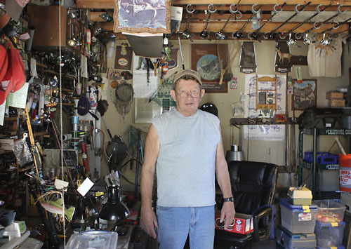 photo of man in garage stuffed with fishing gear