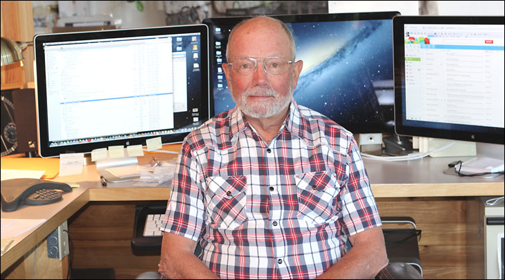 photo of thomas mccord in front of three computer screens