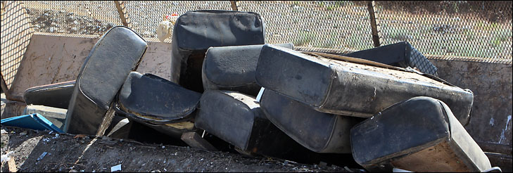 photo of old car seats in transfer station container