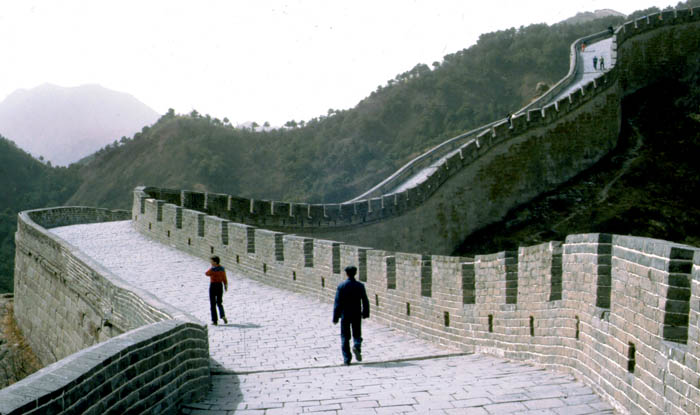 Photo of great wall of China with chinese man and Diana Hottell walking on top.